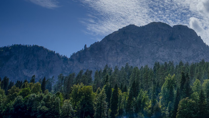 Plakat Natural landscape with mountains and forests against the sky.