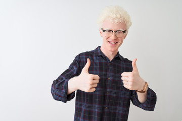 Young albino blond man wearing casual shirt and glasses over isolated white background success sign...