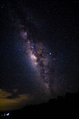 Night landscape with the Milky Way and light from home at mountains in Thailand