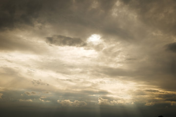 Beautiful dramatic stormy sky and cloud before sunset with god light. Yellow golden light beam with sun rays between cumulonimbus cloudscape. 