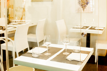 White glass elegant restaurant interior. Empty cafe or bar. Modern luxury dining room with tables and chairs in shopping mall. Catering business