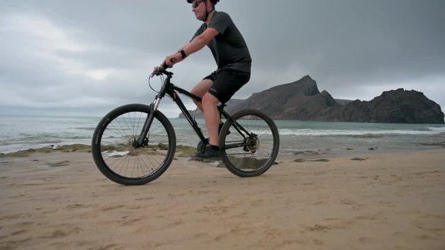 Tourist rides bicycle on the sand on the beach 