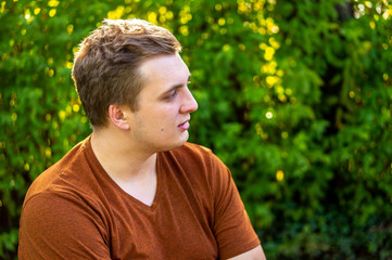 A young guy in a brown shirt communicates in a Park