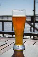 Closeup of long beer glass in an outdoor restaurant.