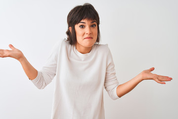 Young beautiful woman wearing casual t-shirt standing over isolated white background clueless and...