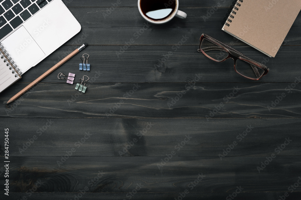 Poster modern dark wood office desk table with laptop, smartphone and other supplies with cup of coffee. co