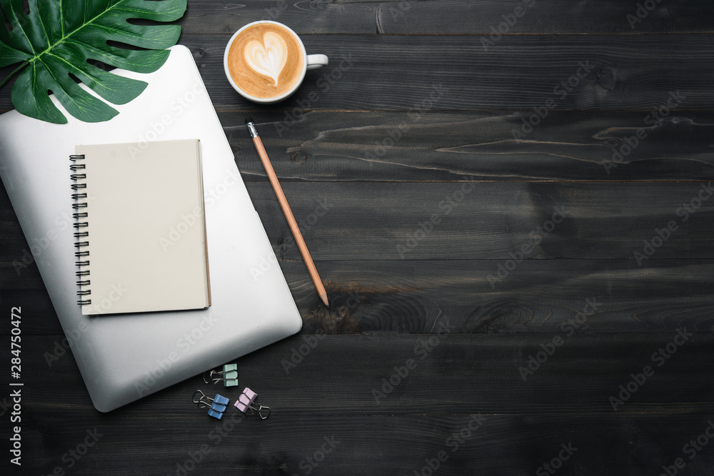 Poster modern dark wood office desk table with laptop, notebook and other supplies with cup of coffee. copp