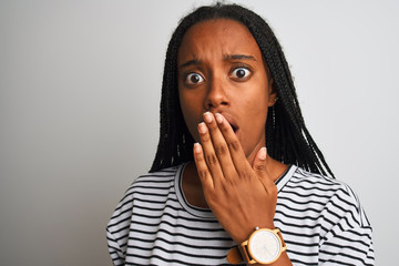 Young african american woman wearing striped t-shirt standing over isolated white background cover mouth with hand shocked with shame for mistake, expression of fear, scared in silence, secret concept