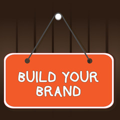 Obraz na płótnie Canvas Writing note showing Build Your Brand. Business concept for enhancing brand equity using advertising campaigns Memo reminder empty board attached background rectangle