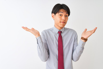 Chinese businessman wearing elegant tie standing over isolated white background clueless and...