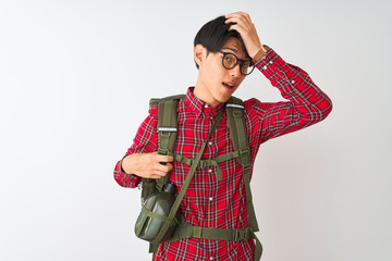 Chinese hiker man wearing backpack canteen glasses over isolated white background surprised with...
