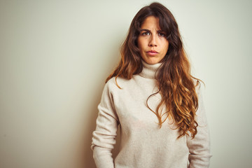 Obraz premium Young beautiful woman wearing winter sweater standing over white isolated background skeptic and nervous, frowning upset because of problem. Negative person.
