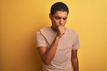 Young handsome arab man wearing striped t-shirt standing over isolated yellow background feeling...