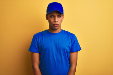 Young handsome arab delivery man standing over isolated yellow background skeptic and nervous, frowning upset because of problem. Negative person.
