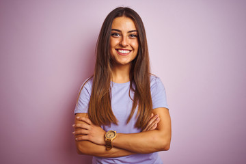 Obraz premium Young beautiful woman wearing casual t-shirt standing over isolated pink background happy face smiling with crossed arms looking at the camera. Positive person.