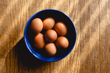 brown eggs in ceramic blue bowl