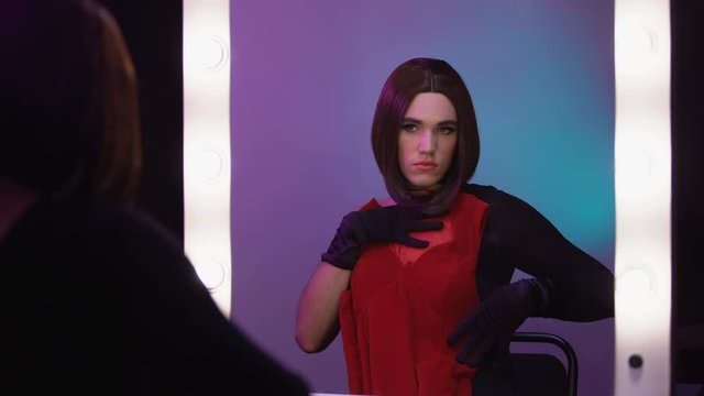 Attractive travesty diva trying on dresses, clothing style as self-expression