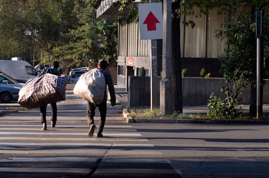 Homeless on the street with bags on their shoulders. - Powered by Adobe