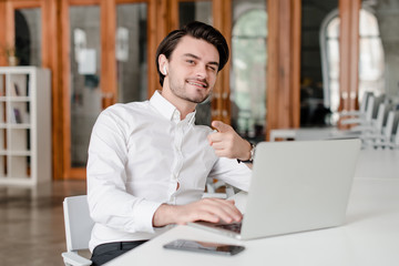 man at his workplace with phone and laptop in the office