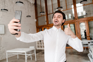 man making selfie with thumbs up on his phone