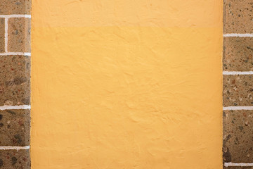 Yellow wall with stone margins, background with space for text, banner or slogan.