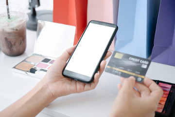 Mockup image of Beautiful woman holding credit card shopping online with smartphone on online websites, mockup concept
