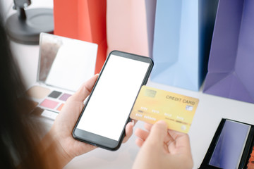 Mockup image of Beautiful woman holding credit card shopping online with smartphone on online websites, mockup concept