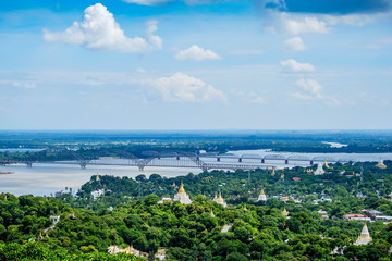Fototapeta premium Irrawaddy Bridge or Ayeyarwady, Yadanabon Bridges with Mandalay city, temples, pagoda, Irrawaddy river. View from sagaing hill. landmark and popular for tourists attractions in Myanmar