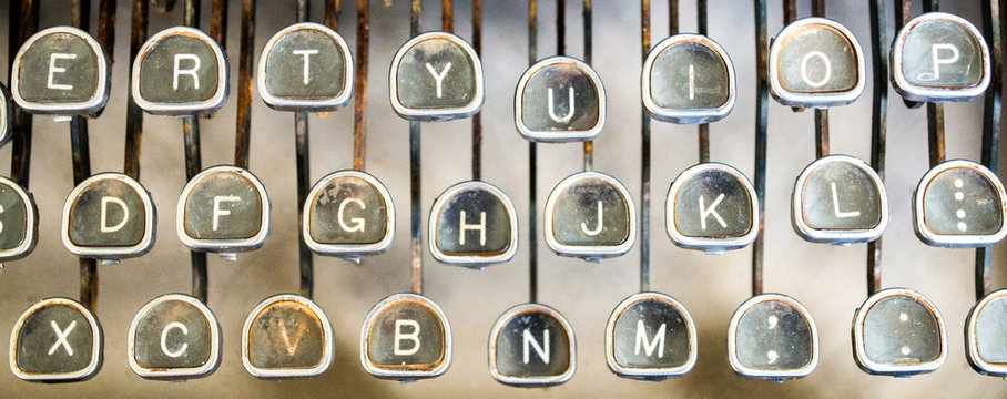 close up of three rows of letter keys on a vintage rusted typewriter viewed from above