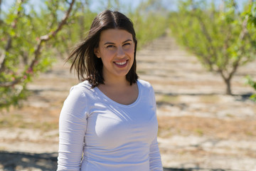 Beautiful young woman smiling cheerful at green trees garden on a sunny day of spring