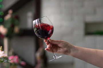 Hand sommelier holding glass of red wine. Swirling wine glass in wine tastings  Red wine concept. Wine tour. Space for text.