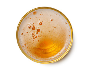 top view of beer bubbles in glass cup on white background.