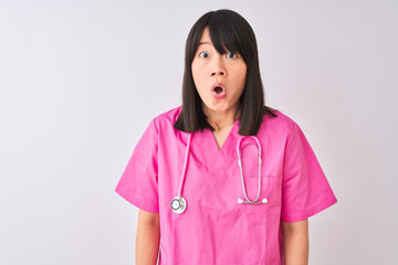 Young beautiful Chinese nurse woman wearing stethoscope over isolated white background afraid and shocked with surprise expression, fear and excited face.