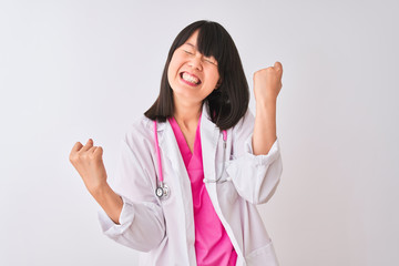 Young beautiful chinese doctor woman wearing stethoscope over isolated white background very happy and excited doing winner gesture with arms raised, smiling and screaming for success. 