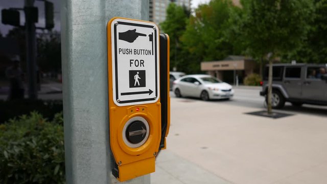 Woman pressing button for crossing the street with 4k resolution.