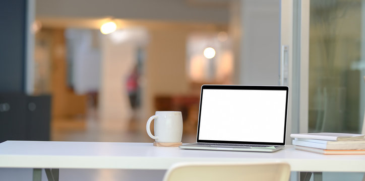 Stylish home-office with open blank screen laptop computer