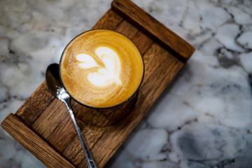 The latte art coffee served within ceramic cup