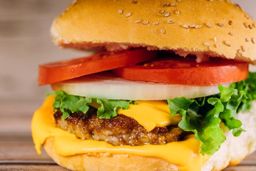 Close up of colorful burger on wooden table.