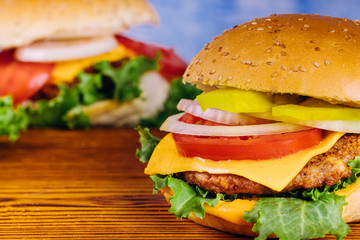 Homemade burgers on wooden background. Close up.