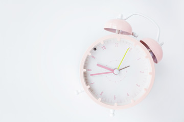 Vintage alarm clock pink color on white background. Rest hours time of life good. Flat lay, top...