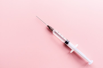 Medical syringe on pink background, health and vaccination concept. Flat lay, mockup, overhead, top view and copy space.