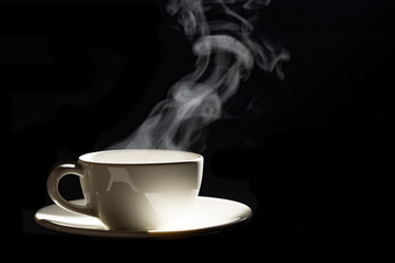 cup of coffee with steam on black background