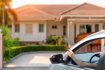 Woman in car, hand holding and using remote control to open the auto gate. Security system concept.	