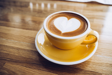 hot cappuccino coffee cup on wooden tray with heart latte art on wood table at cafe,Banner size...