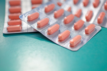 Pink capsules in blister packaging, arranged with beautiful patterns and flashes Pharmaceutical industry concept Pharmacy, pharmacy Antibiotic resistance on pastel colors.soft focus.