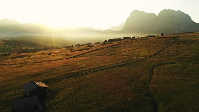 Aerial video of the sunrise in the Dolomites mountains. It was shot on the beautiful meadows of Seiser Alm plateau.