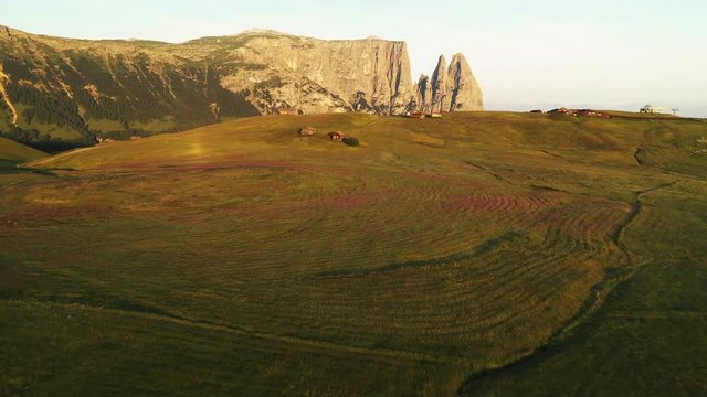 Aerial video of the sunrise in the Dolomites mountains. It was shot on the beautiful meadows of Seiser Alm plateau.
