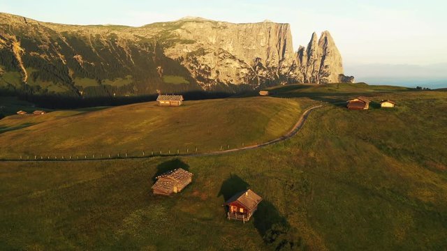 Aerial video of the sunrise in the Dolomites mountains. It was shot on the beautiful meadows of Seiser Alm plateau.