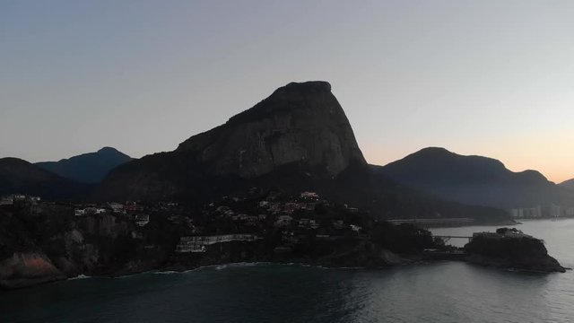Aerial approach of Joatinga beach with the Gavea mountain in the background and Costa Brava club on an island in the foreground at dawn in Rio de Janeiro