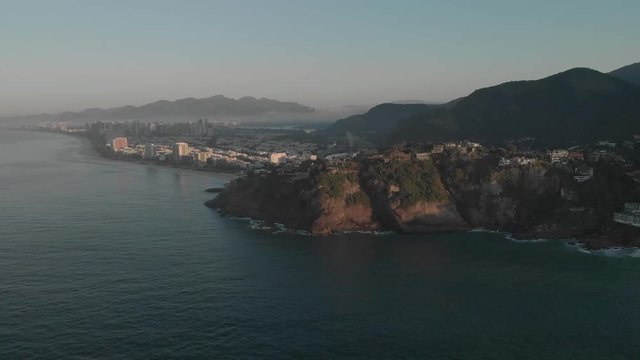 Aerial of the vast neighbourhood of Barra da Tijuca in Rio de Janeiro with morning mist revealing the cliffs of Joatinga beach with Gavea mountain behind in Rio de Janeiro at sunrise